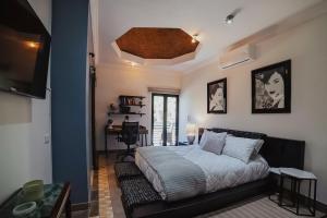 a bedroom with a bed and a tv and a desk at Casas Blancas, Planta Alta in Todos Santos