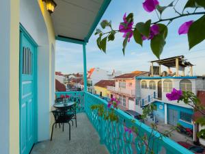 a balcony with a table and chairs and purple flowers at Casa Ramona in Flores