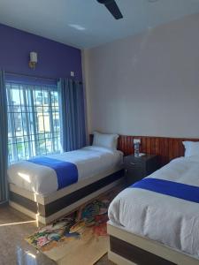 a hotel room with two beds and a window at Hotel namo buddha in Sauraha