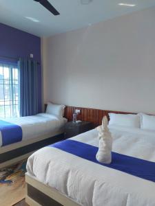 two beds in a hotel room with two at Hotel namo buddha in Sauraha +5 photos