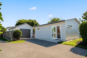 a house with a garage and a driveway at Studio 17 Private Standalone Studio in Greenhithe North Shore in Auckland