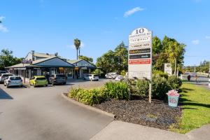 a street sign with cars parked in a parking lot at Studio 17 Private Standalone Studio in Greenhithe North Shore in Auckland