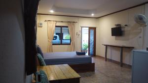 a bedroom with a bed and a table in it at Baanpuklertsuk in Ban Map Ta Put