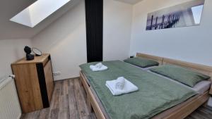 a bedroom with two beds with white towels on them at Apartmán Kovadlina 5 - Kovářov, výhled na Lipno in Frymburk