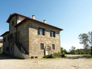 an old stone building with black shutters on it at Belvilla by OYO Sangiovese in Poggio Alla Croce