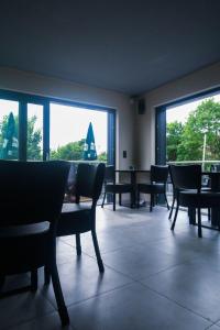 a dining room with chairs and a table and windows at Hotel Löwenstein in Lich