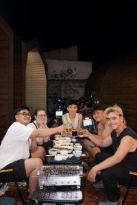 a group of people sitting around a table with food at New Sky Homestay in Chợ Phước Hải +10 photos