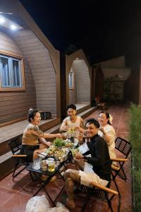 a group of people sitting around a table eating food at New Sky Homestay in Chợ Phước Hải