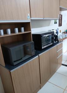 a kitchen with a microwave and a toaster oven at Hostel do Gui in Alto Paraíso de Goiás