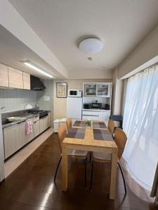 a kitchen with a table and chairs in a room at kotobuki504condotel in Imai-kamichō