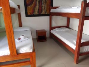 a room with three bunk beds and a table at Alojamiento PLAYA DORADA Coveñas in Coveñas