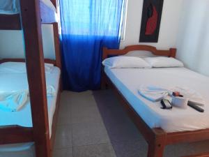 a bedroom with two bunk beds and a blue curtain at Alojamiento PLAYA DORADA Coveñas in Coveñas
