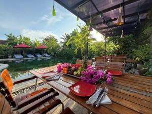 a table with a bowl of fruit and flowers on it at Maso Christian Villa Canggu in Tumbak Bayuh