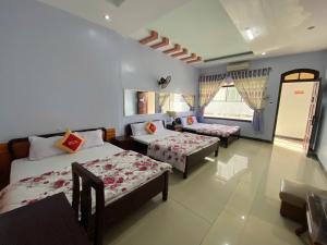 a hotel room with two beds and a window at Khách Sạn Ninh Thọ in Quảng Ngãi