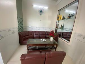 a living room with a leather couch and a table at Khách Sạn Ninh Thọ in Quảng Ngãi