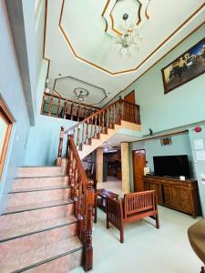 a living room with a staircase and a television at The Orange House - Vigan Villa in Vigan