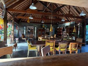 a restaurant with tables and chairs and a dog in the room at Maso Christian Villa Canggu in Tumbak Bayuh