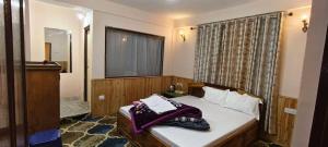 a bedroom with a bed with a mirror and a window at Vedanth Retreat Homestay in Kalimpong