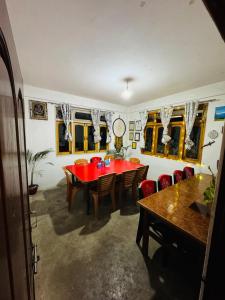a dining room with a red table and chairs at Vedanth Retreat Homestay in Kalimpong