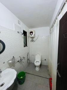 a bathroom with a white toilet and a sink at Vedanth Retreat Homestay in Kalimpong
