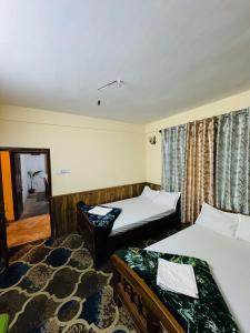 a hotel room with two beds and a mirror at Vedanth Retreat Homestay in Kalimpong