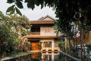 a house with a pool in front of it at Isann Suites in Phumĭ Réach Born (1)