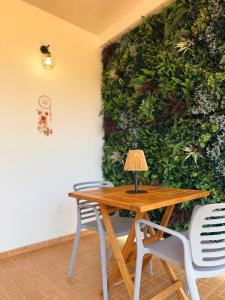 a table and chairs in front of a green wall at Fare Hinenao in Tevaitoa