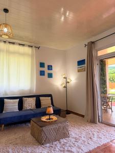 a living room with a blue couch and a table at Fare Hinenao in Tevaitoa