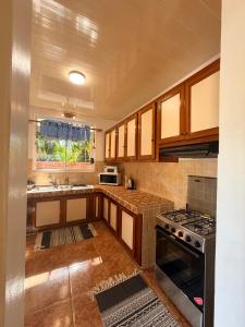 a kitchen with wooden cabinets and a stove top oven at Fare Hinenao in Tevaitoa