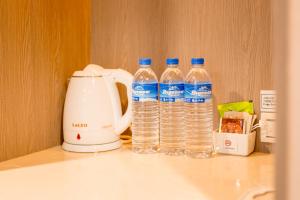 two bottles of water sitting on a counter next to a blender at VIP Hotel in Taipei
