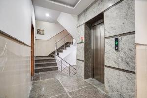 a hallway with a staircase with a door and a stair case at Hotel IBY in New Delhi