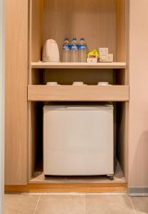 a cupboard with bottles of water and a microwave at VIP Hotel in Taipei