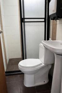 a bathroom with a toilet and a sink at Aparta Suites Torre de Prado 601 Apartamento para 9 Personas in Medellín +26 photos
