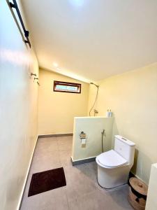 a bathroom with a white toilet in a room at Kapal Dream Homestay in Selong Belanak