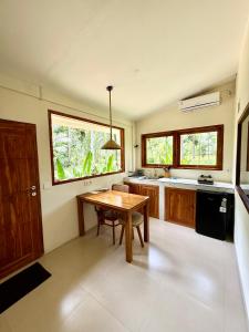 a kitchen with a wooden table and a sink and a table at Kapal Dream Homestay in Selong Belanak +10 photos