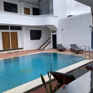 a swimming pool with two chairs next to a building at Hospedaje Zerimar in Puerto Baquerizo Moreno