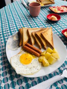 a plate of breakfast food with eggs sausage and toast at Ocean Breeze in Dickwella