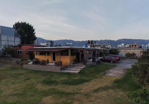 a house in a field with a car parked at EL MIRADOR dlr HR in Quetzaltenango