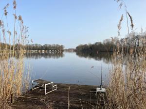 a bench sitting on a dock on a lake at Twee slaapkamer stacaravan met vissteiger in Hengelo