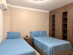 two beds in a room with blue sheets at Kiosco Azul - Apartamento amoblado cerca al mar in Ríohacha