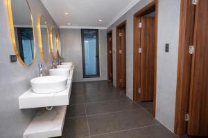 a bathroom with three sinks and a row of mirrors at Ha Giang Numa Hotel in Ha Giang