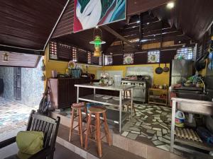 a kitchen with a table and some stools in it at Gio Private Villa - Langkawi in Langkawi Intl