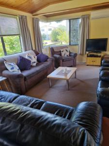 a living room with couches and a coffee table at Estuary Hideaway in Whangamata