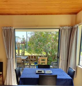 a dining room with a table and a large window at Estuary Hideaway in Whangamata +16 photos