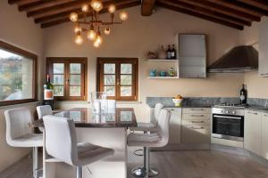 a kitchen with white chairs and a table with a counter at Fienile in Pontassieve