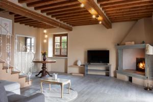 a living room with a fireplace and a tv at Fienile in Pontassieve