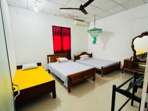a room with two beds and a piano at Pudam Cottege in Kataragama