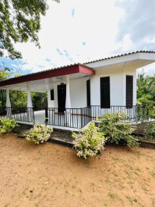 a white house with plants in front of it at Pudam Cottege in Kataragama