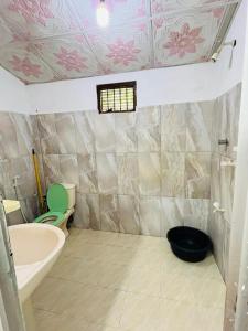 a bathroom with a tub and a toilet and a sink at Pudam Cottege in Kataragama