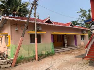 a house with a green and pink at abirami arulagam in Jāmb